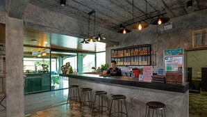 Un espace bar comprenant un comptoir, des tabourets et un réfrigérateur rempli de boissons.