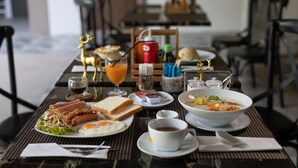 Une table de petit-déjeuner avec divers plats, notamment des œufs, des toasts et un bol de soupe.