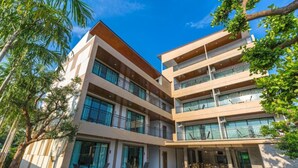 Un hôtel à plusieurs étages doté d’une piscine, d’un espace extérieur aménagé et de balcons.