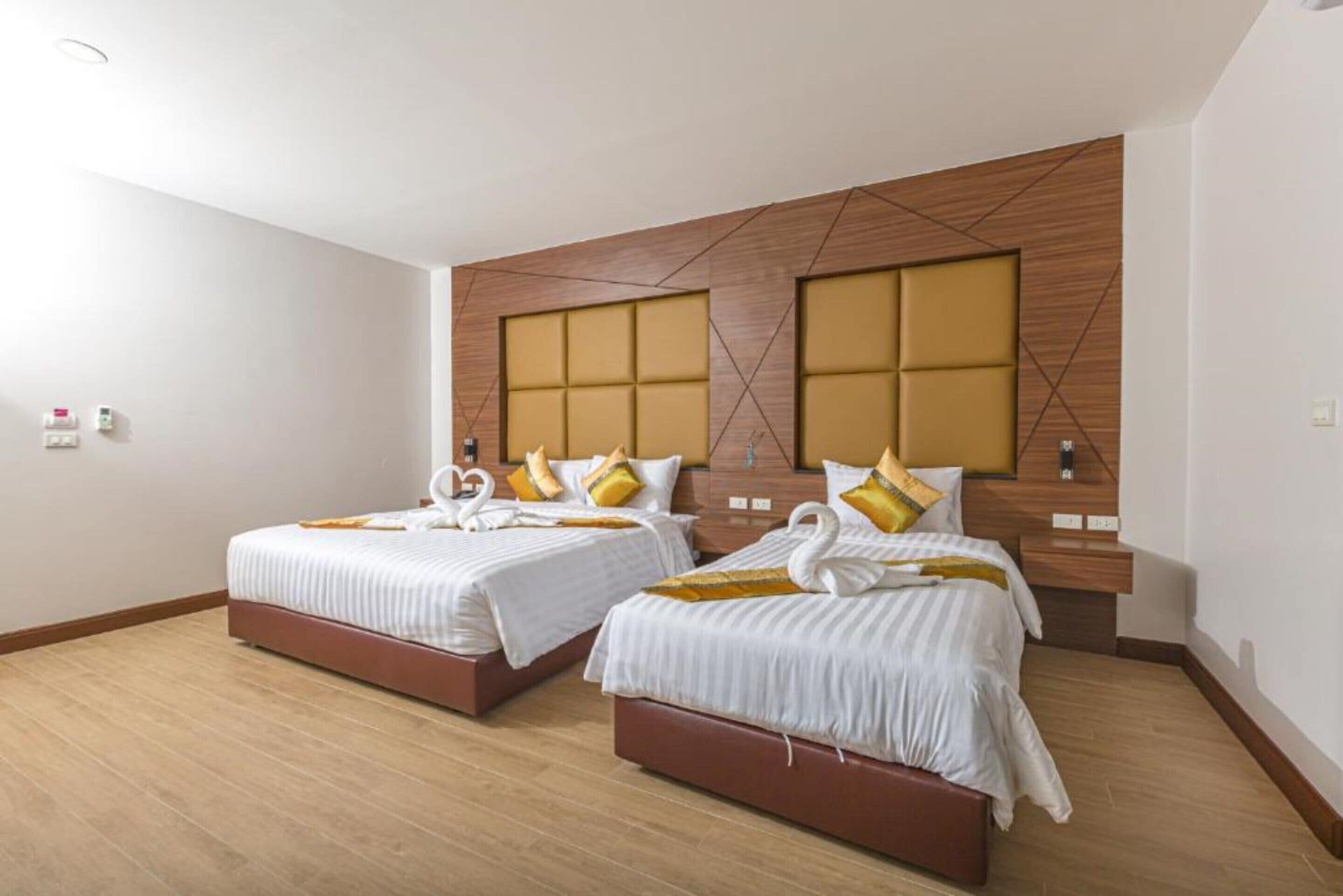 Habitación de hotel con dos camas y cabeceros de madera, de diseño moderno.
