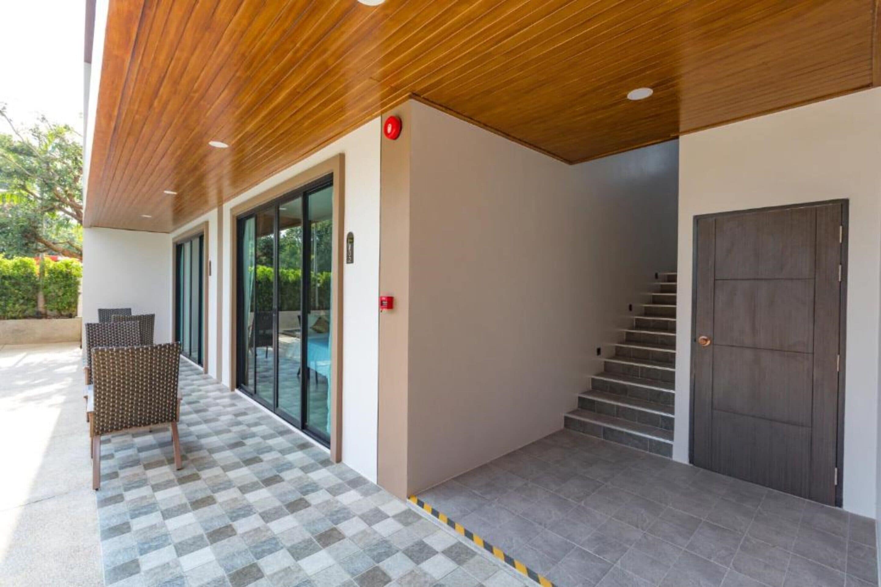 A modern building entrance with a checkered floor, a staircase, and a door.