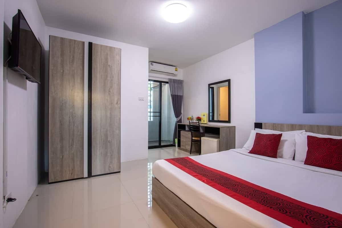 Ein modernes Hotelzimmer mit einem großen Bett, einem Schreibtisch und einem Kleiderschrank.