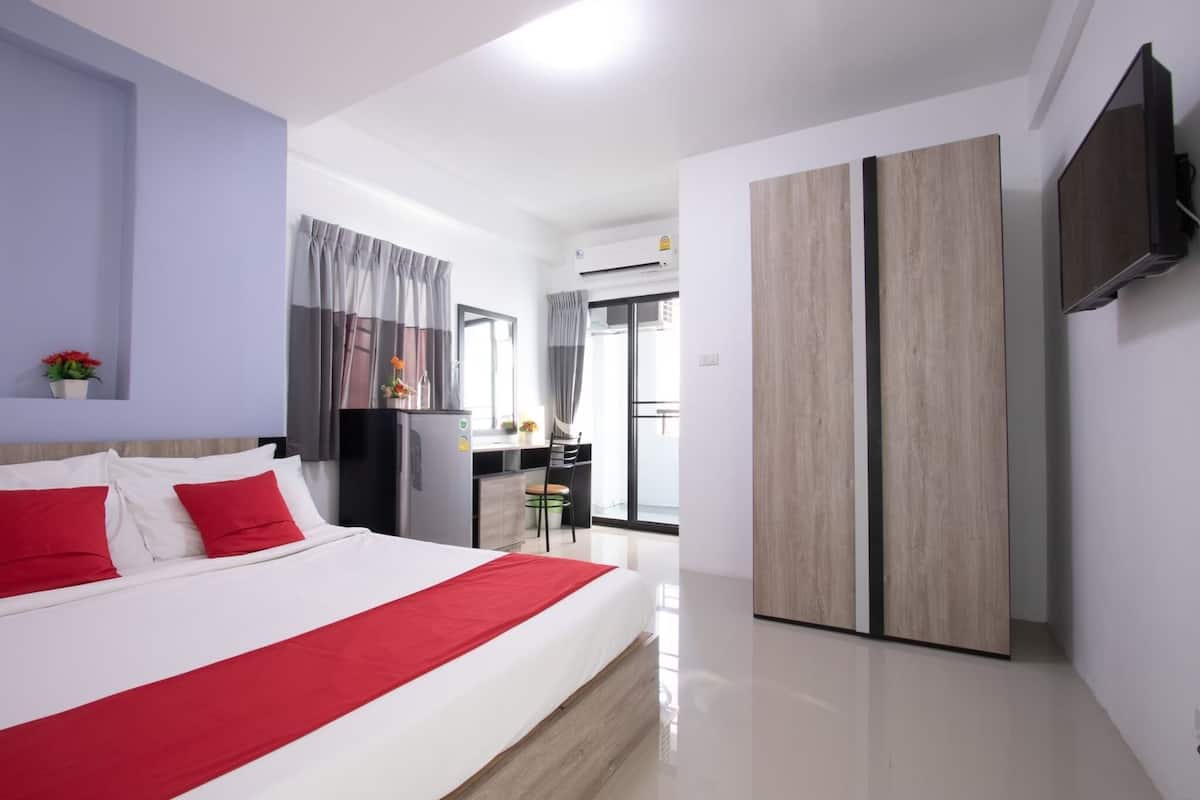 Ein modernes Hotelzimmer mit einem großen Bett, einem Schreibtisch und einem Kleiderschrank.