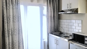 A kitchen with a stove, sink, and cabinets. - Selton Guest House (Cape Town)