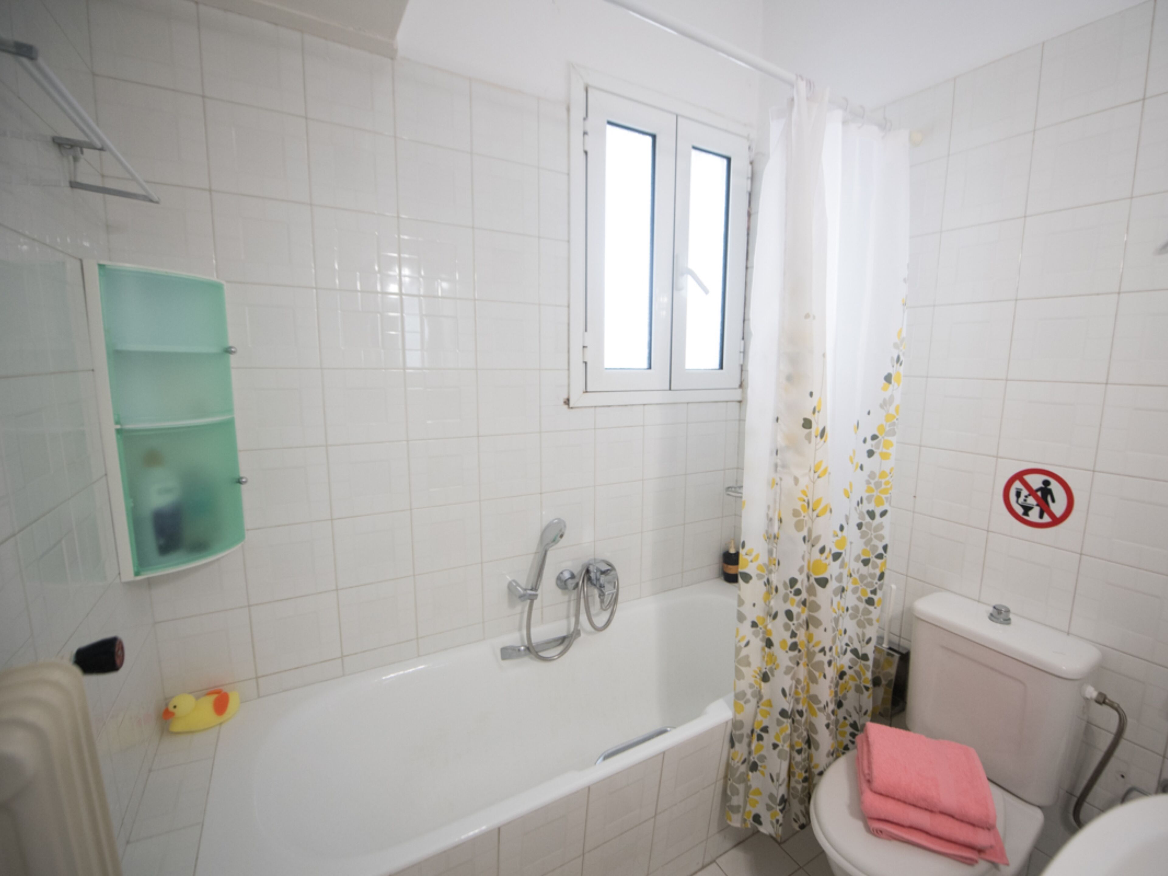 Une salle de bain avec une baignoire, des toilettes et une fenêtre.