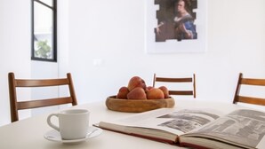 Ein Tisch mit einer weißen Tasse, einer Schüssel Pfirsiche und einem offenen Buch.