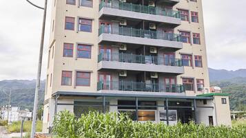 A multi-story building with balconies, air conditioning units, and a flat roof.