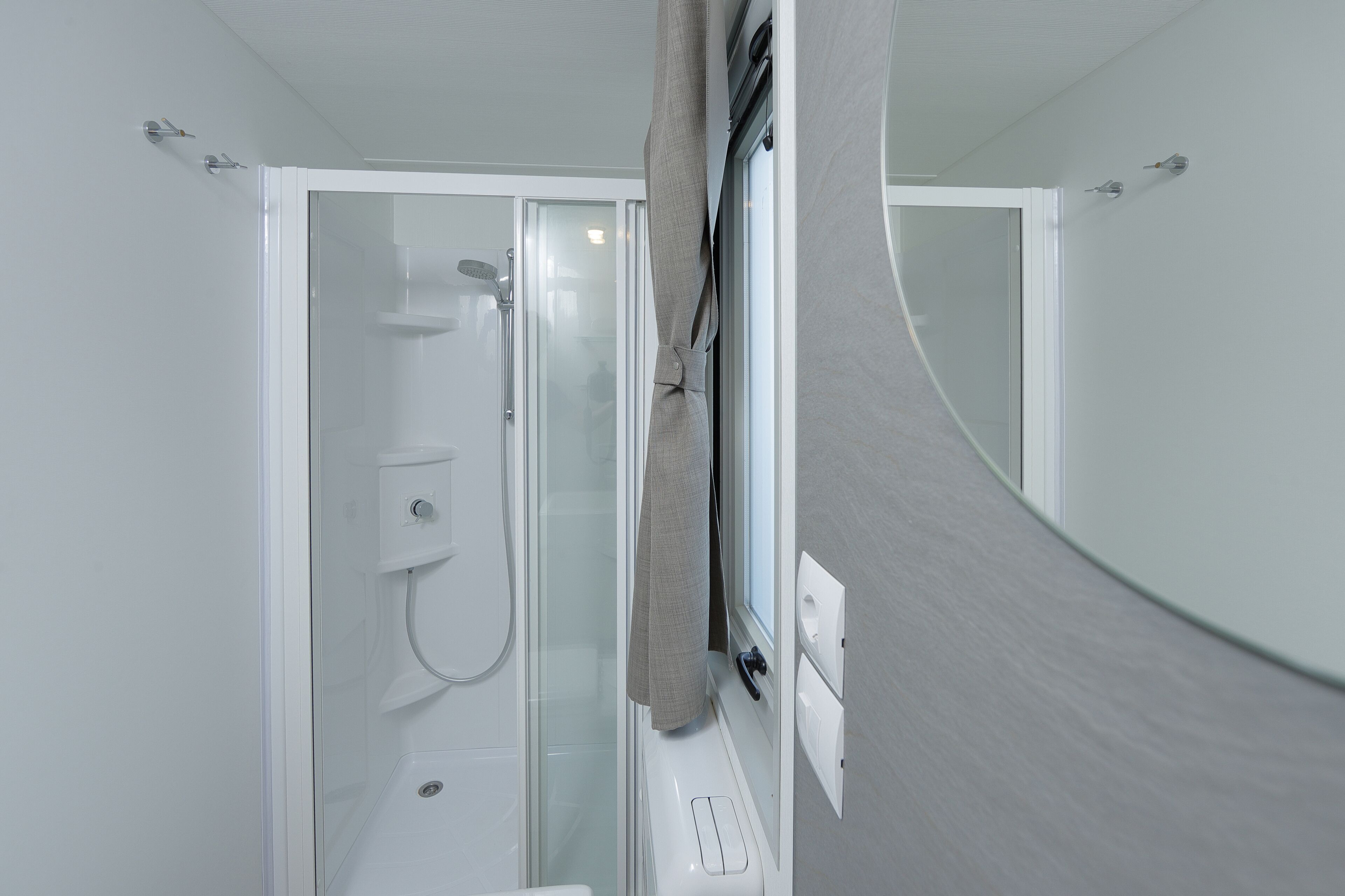 Une salle de bain avec une douche à parois en verre, des toilettes et un lavabo.