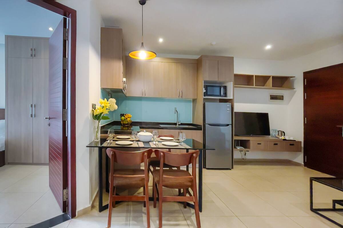 Une cuisine moderne équipée d’une table à manger pour quatre personnes, d’un four à micro-ondes et d’un réfrigérateur.