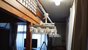 A traditional Japanese room with tatami flooring, a futon bed, a ceiling fan, and a TV. - Free parking, free pets, free cleaning (糸満市)