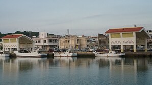 A harbor with boats docked, buildings with red roofs, and a clear sky. - Free parking, free pets, free cleaning (糸満市)