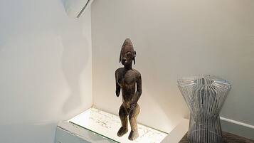 A staircase with a small statue and a metal sculpture on the landing.