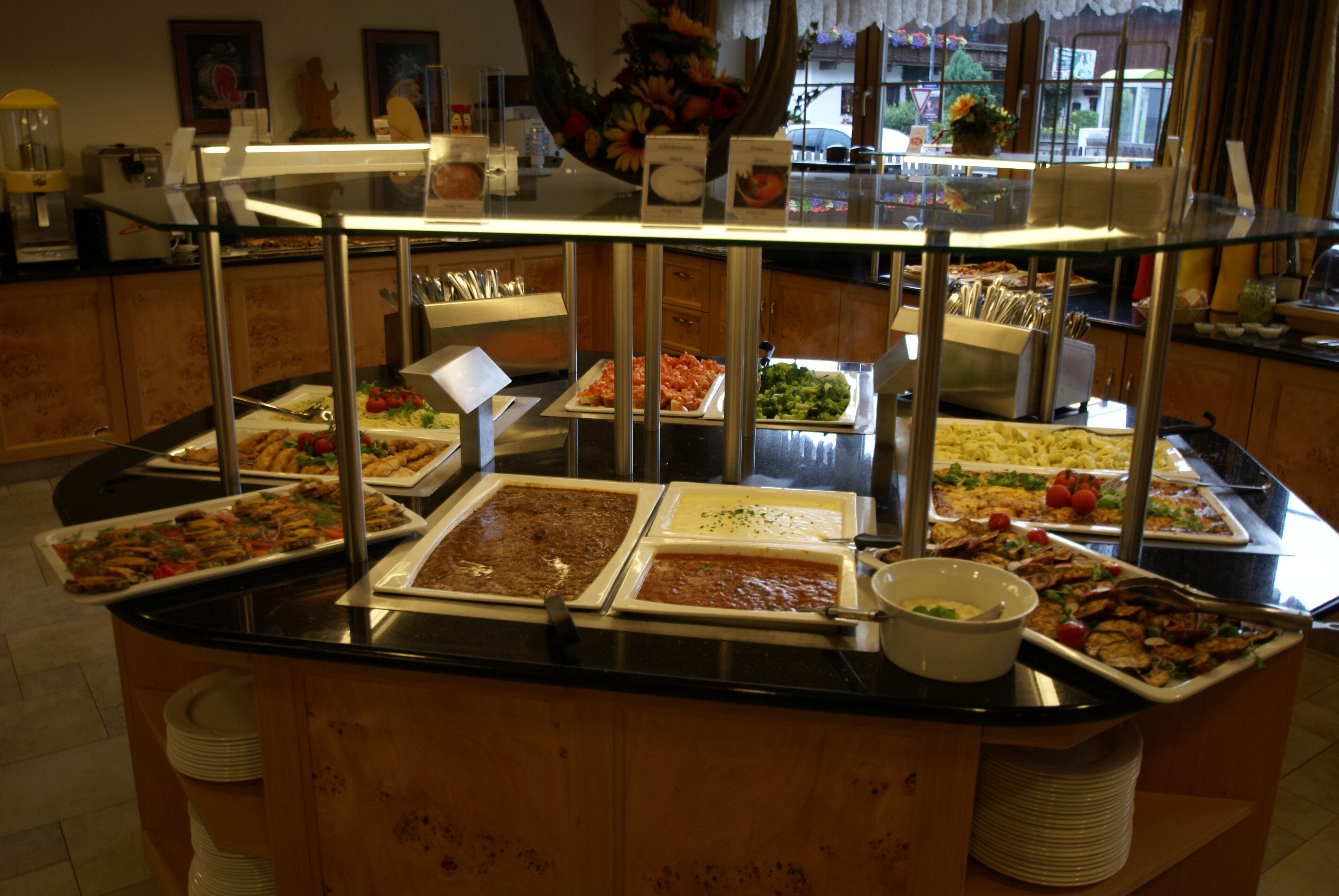 A buffet with various food items and a glass display case.