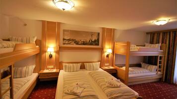 Una habitación de hotel con literas, una cama grande y un cuadro en la pared.