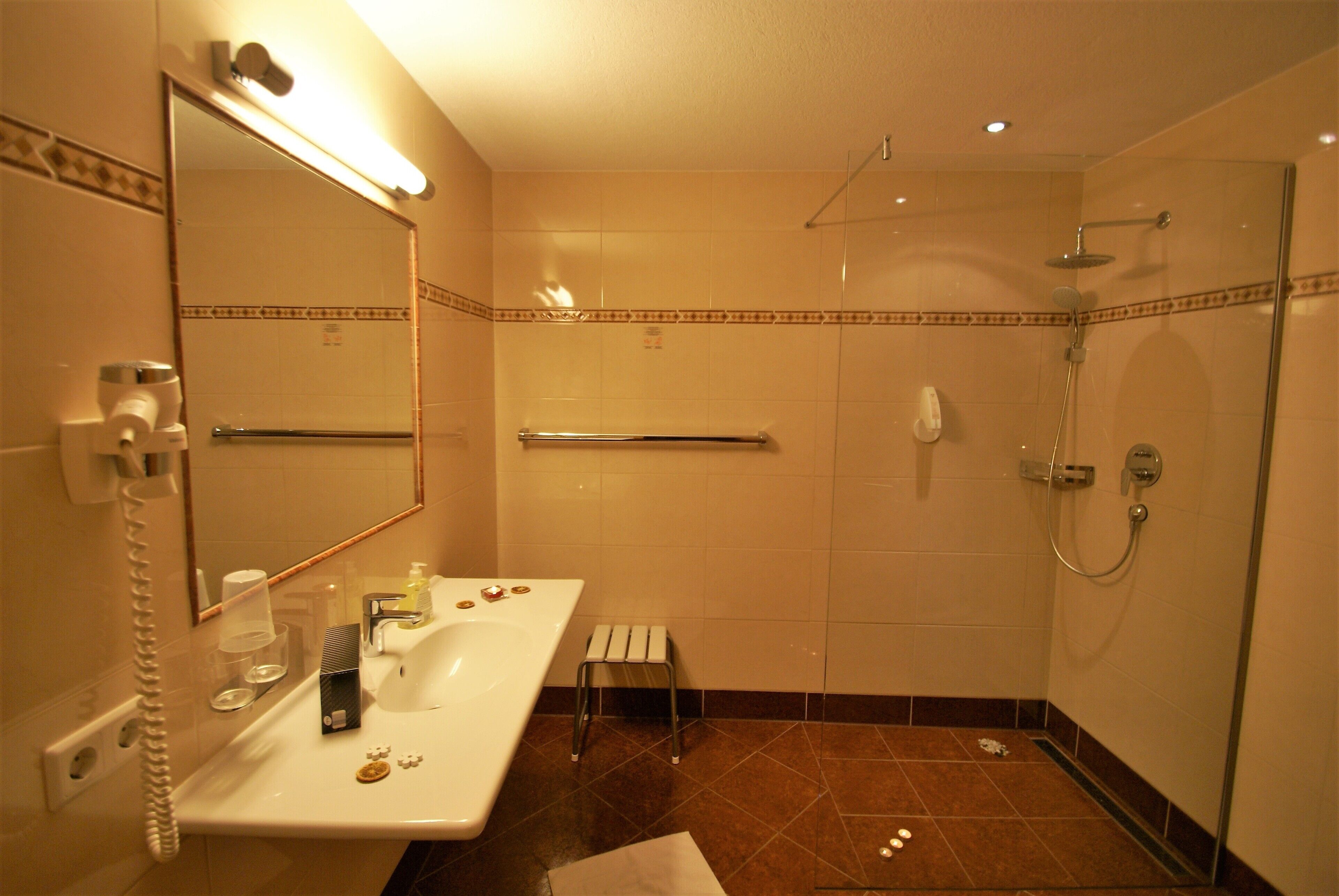 Un baño con lavamanos, espejo y ducha.