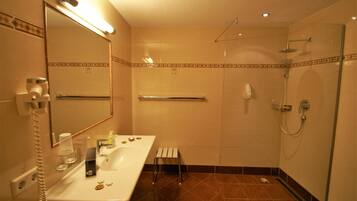 Un baño con lavamanos, espejo y ducha.