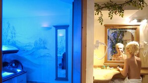 Ein Wellnessraum mit blau beleuchteter Wand, einem Holzschrank und einem Spiegel.