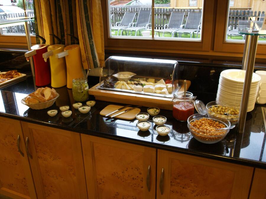 A buffet setup with various food items and condiments.
