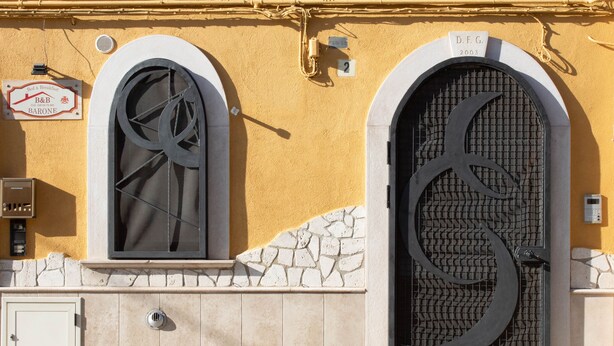 A building facade with a large arched window and a decorative metal gate. - Bed & Breakfast in the center of Rionero In Vulture (Rionero In Vulture)