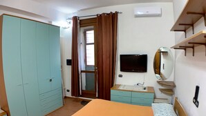 A bedroom with a bed, a wardrobe, a television, and a mirror. - Bed & Breakfast in the center of Rionero In Vulture (Rionero In Vulture)