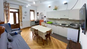 A compact living space with a dining area, kitchenette, and a small TV. - Bed & Breakfast in the center of Rionero In Vulture (Rionero In Vulture)