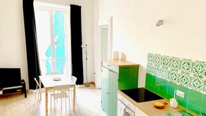 A kitchen with a dining table, chairs, a stove, and a sink. - La piazzetta - Naples (Napoli)