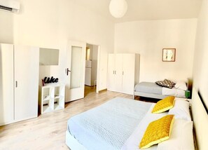 A bedroom with a bed, a wardrobe, a desk, and a door leading to another room. - La piazzetta - Naples (Napoli)