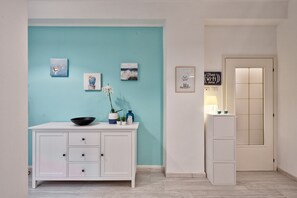 A room with a white cabinet, a teal accent wall, and a door with a sign indicating free Wi-Fi.