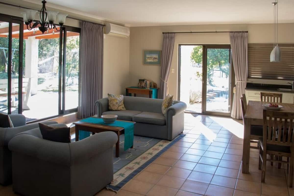 Una sala de estar con sofá, una mesa de centro y una zona de comedor con mesa y sillas.