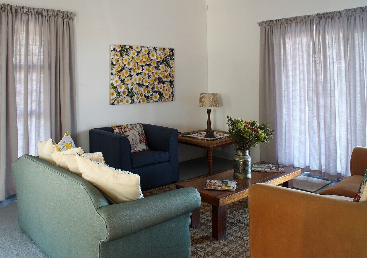A living room with a blue sofa, a green armchair, a wooden coffee table, and a lamp.
