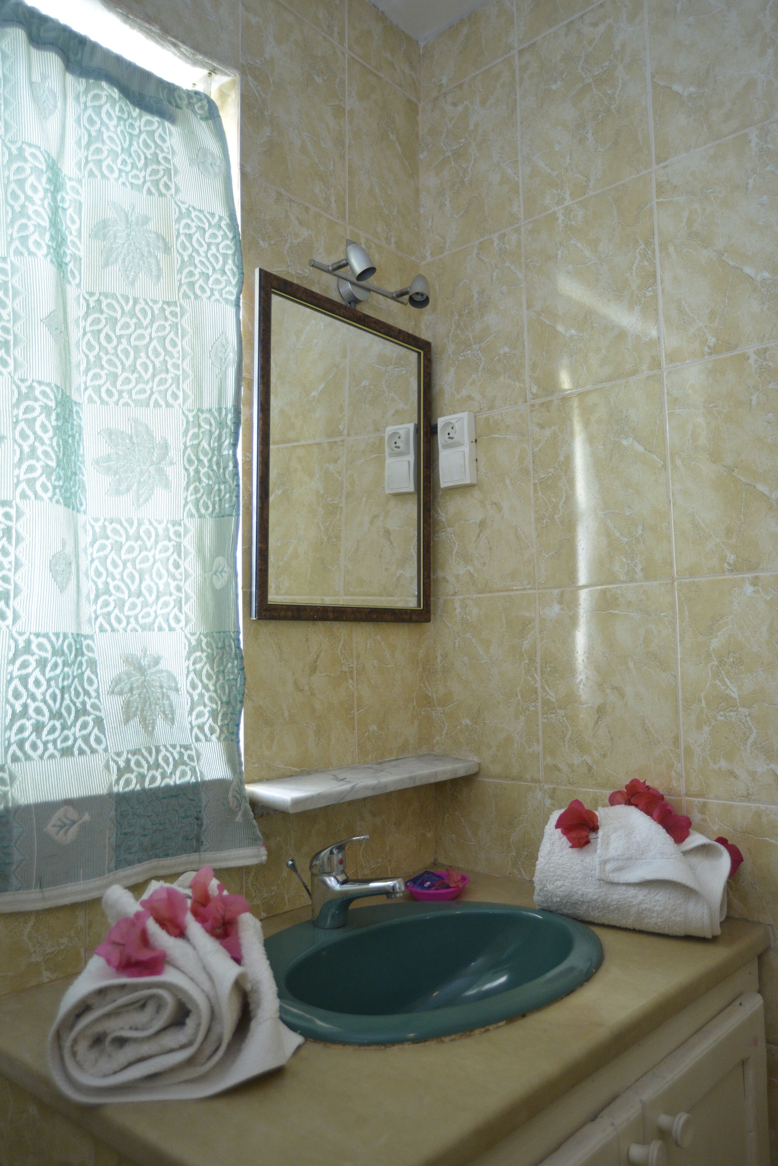 A bathroom with a sink, mirror, and towel rack.