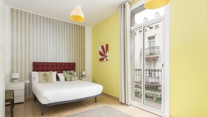Un dormitorio con cama, mesitas de noche, una ventana con vistas y una puerta.