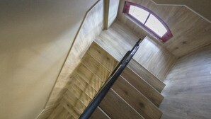 Una escalera con escalones de madera y un ventanal en la parte superior.