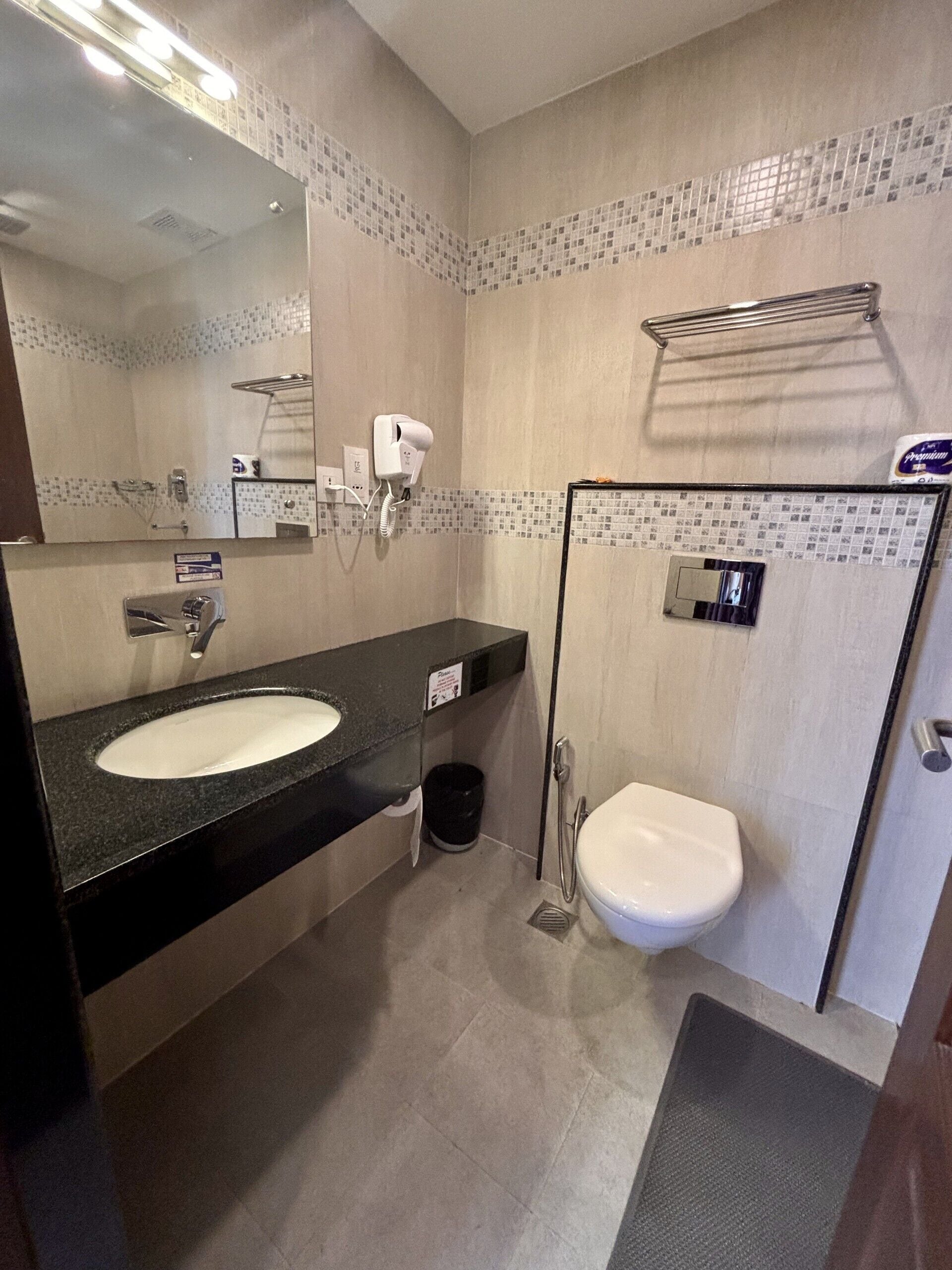 Un baño moderno con un lavamanos grande, un inodoro, una ducha y un espejo.