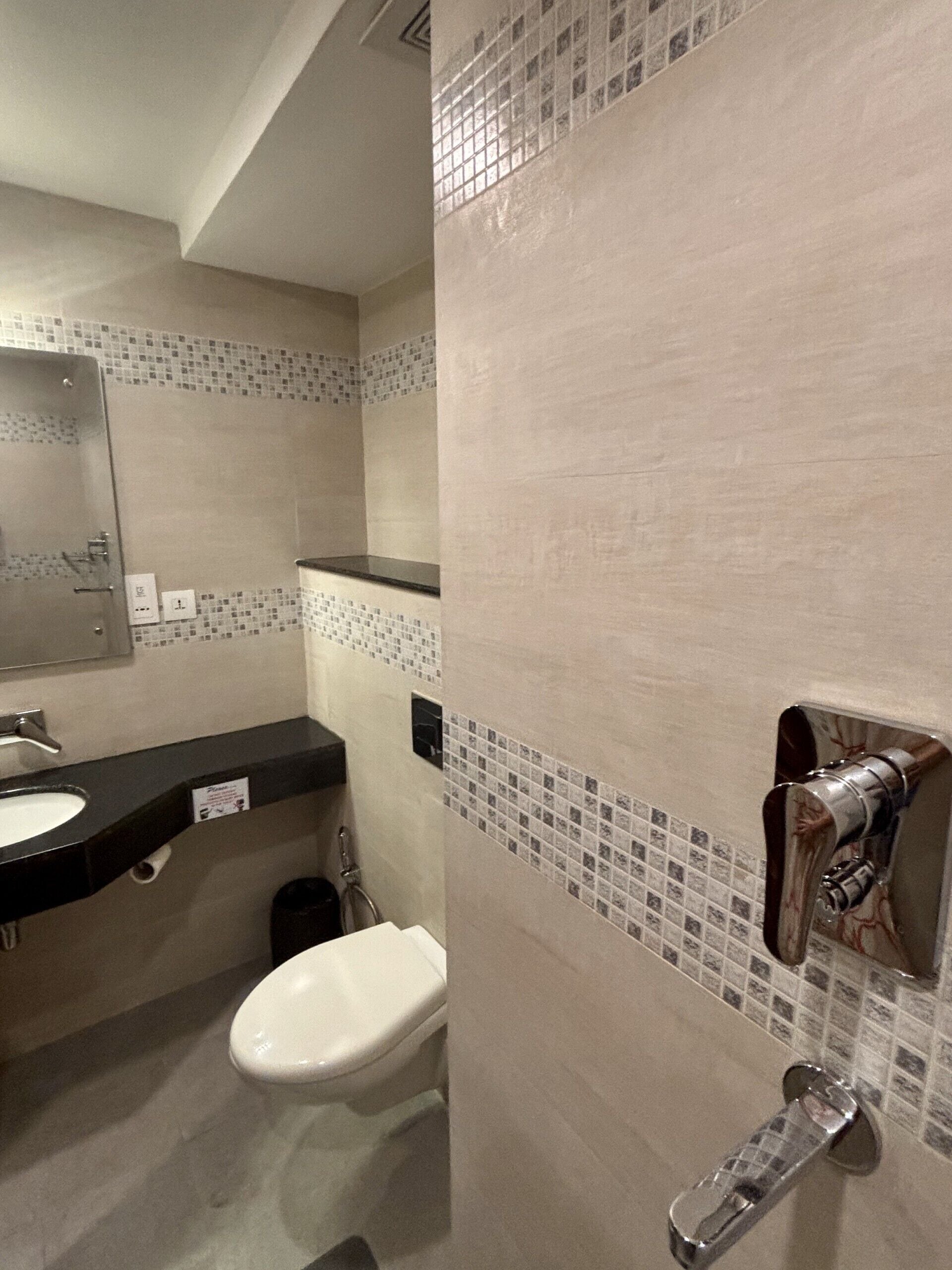 Ein Badezimmer mit Toilette, Waschbecken und Spiegel.