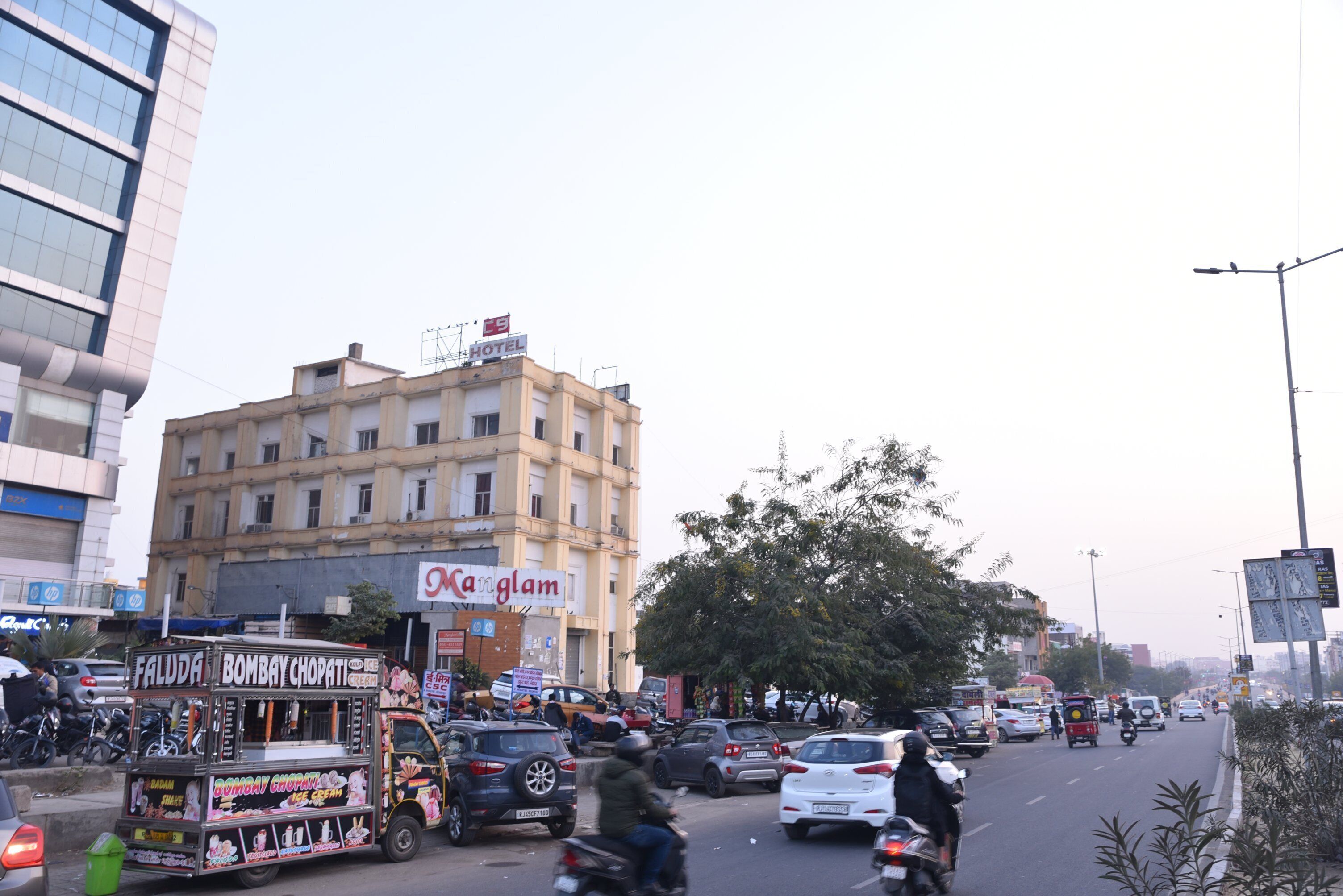 A busy street with a building labeled "Kar Glam" and a food cart named "Bombay Chappati."