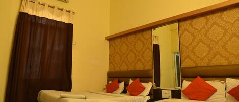 Una habitación de hotel con dos camas, un espejo grande, aire acondicionado y una cortina.