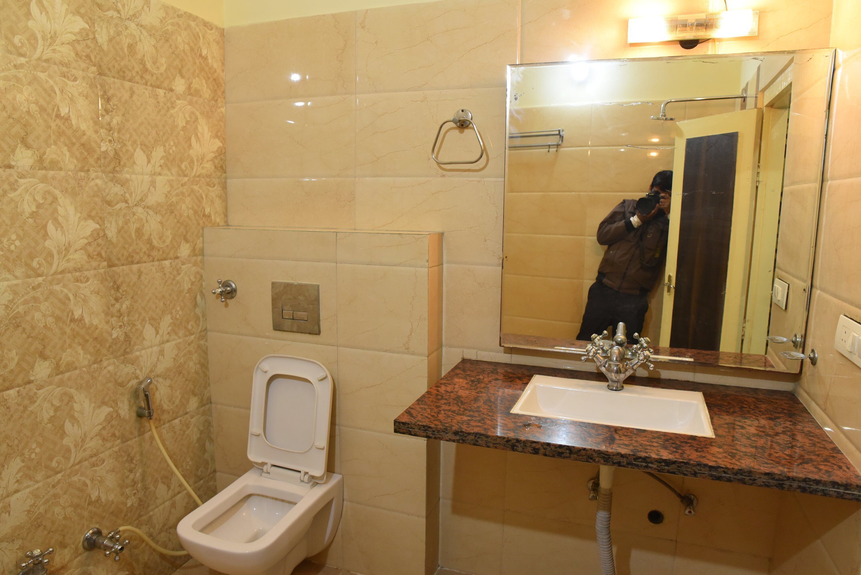 Une salle de bain avec des toilettes, un lavabo et un miroir.