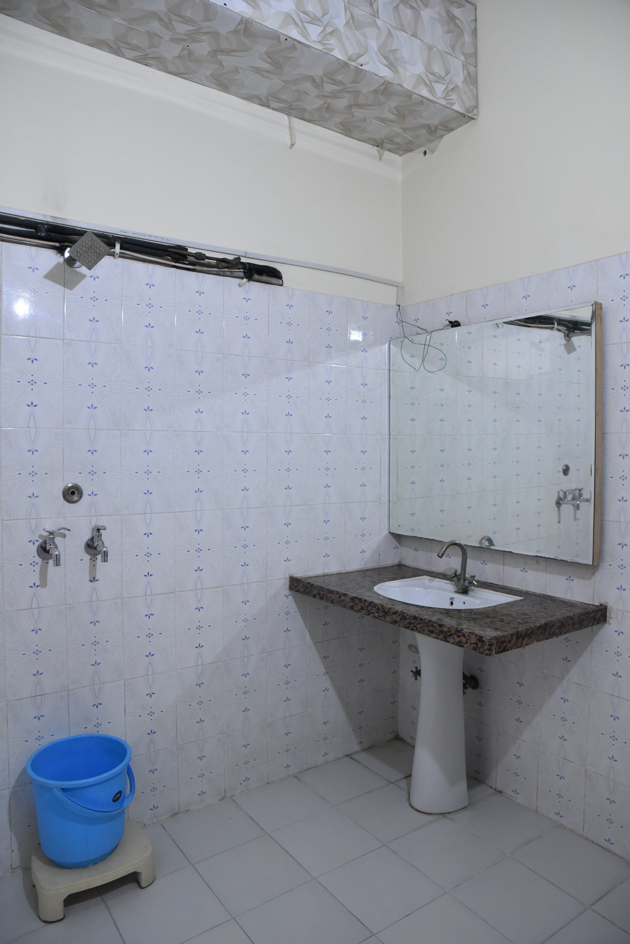A bathroom with a white sink, a mirror, and a shower.