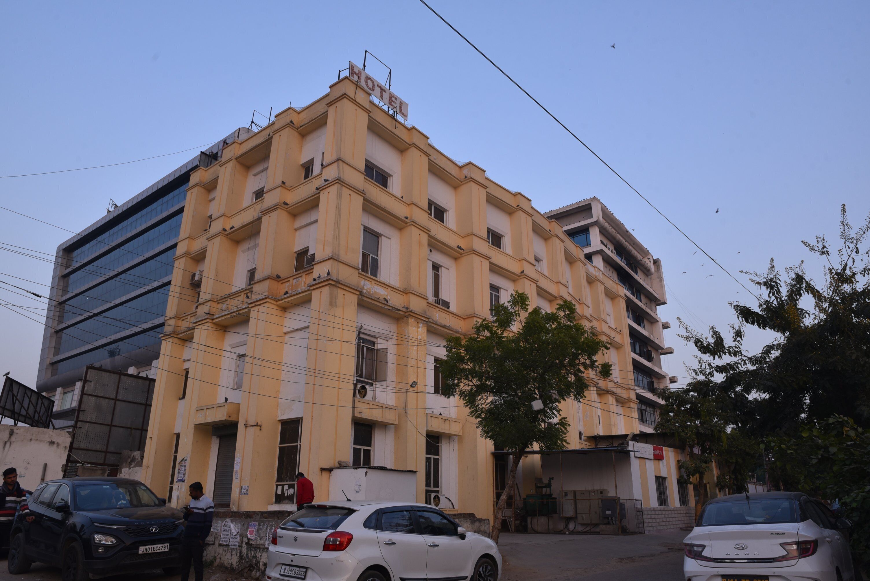 Un hôtel à plusieurs étages, doté d’une façade jaune, de grandes fenêtres et d’une enseigne indiquant qu’il s’agit d’un hôtel.