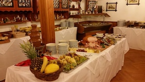 A buffet setup with various food items and a fruit basket. - Landhotel Wettin (Hermsdorf-Erzgebirge)