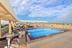 Een binnenzwembad, parasols bij het zwembad en ligstoelen