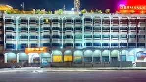 A multi-story hotel with a modern architectural design, featuring balconies and a prominent signage for 'GERMANUS'. - Hotel Germanus (Madurai)