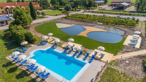 A large swimming pool with multiple lanes, surrounded by sun loungers and umbrellas. - Masorini 1, beautiful apartment near the pool.  Take a break from everyday life! (Palazzolo dello Stella)