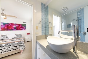 Un baño moderno con un lavabo grande, un espejo y una ducha.