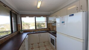 A kitchen with a refrigerator, oven, and sink. - Pinnacle Unit 403 (Forster)