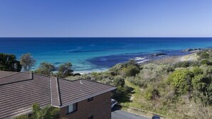 A coastal property with a view of the ocean, a paved driveway, and a brick building. - Pinnacle Unit 701 (Forster)
