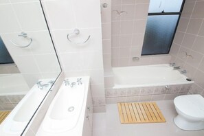 A bathroom with a bathtub, a sink, and a toilet. - Pinnacle Unit 701 (Forster)