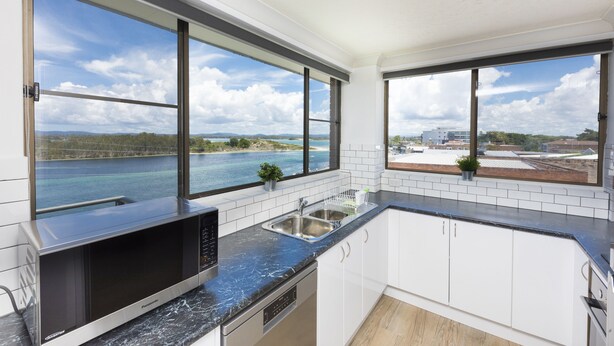 A modern kitchen with large windows, a built-in microwave, and a sink. - Wharf Street Vista (Forster)