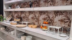 A modern kitchen with marble countertops, built-in shelves, and a tiled backsplash. - Atico Hotel (Desenzano del Garda)